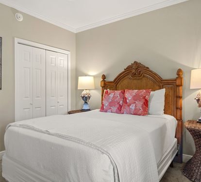 Sink into crisp white linens and tropical comfort in the peaceful bedroom retreat, complete with charming wicker touches and warm coastal lighting.