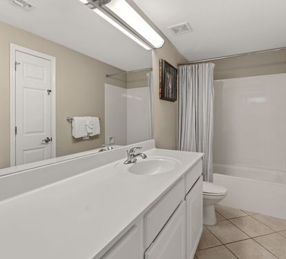 Spacious bathroom features a tub, fresh towels, and clean modern finishes for ultimate relaxation.