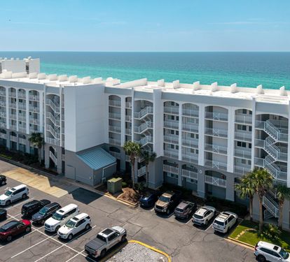 Beachfront property offering direct access to pristine turquoise waters and white sand, with ample parking for your convenience.