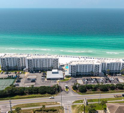 Beachfront property with pristine white sand, emerald waters, and resort-style amenities including tennis courts and swimming pool, all just steps from the Gulf.