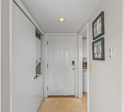 Step into your welcoming entryway, where soft lighting and coastal artwork greet you, setting a relaxed tone the moment you arrive at your coastal retreat.