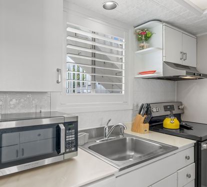 The kitchen features everything needed for easy meal prep, including a stovetop, microwave, coffee maker, and convenient counter space. Bright coastal touches and an open layout make the space feel comfortable and inviting.