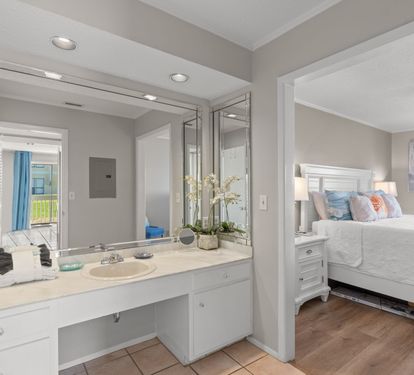 The spacious dressing area offers a large vanity, bright lighting, and plenty of counter space, creating a comfortable spot to get ready while remaining conveniently connected to the primary bedroom.