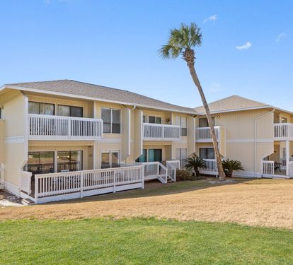 Coastal-inspired buildings featuring private balconies and tropical landscaping define the property's relaxed, beachside atmosphere.