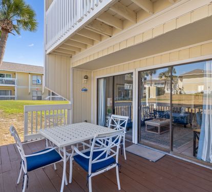 A coastal-style ground-floor patio perfect for morning coffee or evening relaxation, with easy access to your private outdoor space and views of swaying palms.
