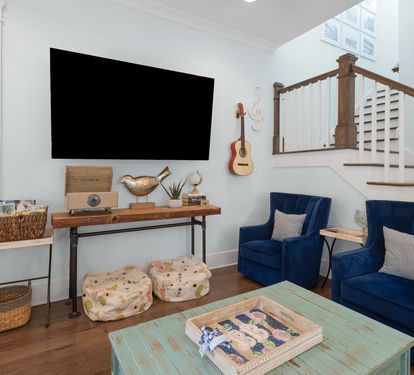 Relax in your charming living room where coastal blues meet warm wood tones, complete with entertainment and cozy seating.