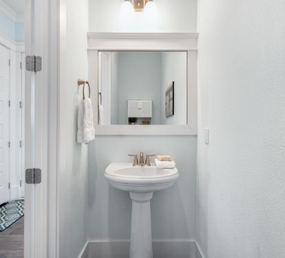 Step into your pristine powder room featuring elegant fixtures and thoughtful touches for your convenience.