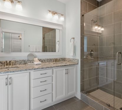 Your spacious bathroom features elegant granite countertops, bright vanity lighting, and a luxurious glass-enclosed shower for ultimate relaxation.