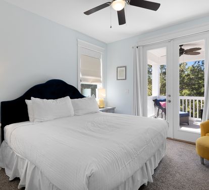 Drift off in this serene bedroom where soft blues meet crisp whites, and your private balcony opens to peaceful treetop views.