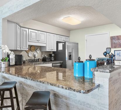 Your spacious kitchen features granite countertops, stainless steel appliances, and a breakfast bar perfect for morning coffee or casual dining.