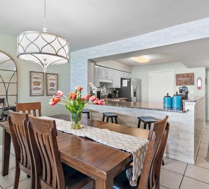 Gather around your spacious dining table with fresh tulips while the open kitchen invites easy meal prep and conversation.