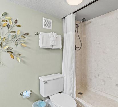 Refresh in your private bathroom featuring a spacious walk-in shower and cheerful tree artwork that brightens your morning routine.