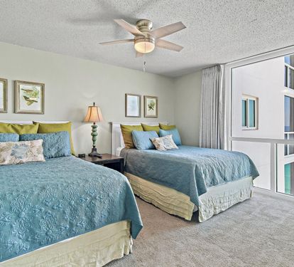 Drift off to sleep in this tranquil bedroom with twin beds dressed in ocean-inspired linens while gentle sea breezes flow through your private space.