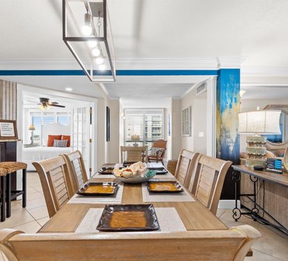 Gather around this elegant dining table where shared meals become cherished memories, with coastal artwork adding warmth to your group celebrations.