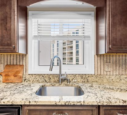 Prepare your favorite meals in this elegant kitchen featuring granite countertops, modern appliances, and a lovely window view.