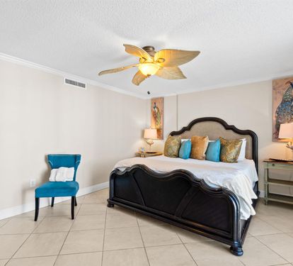 Drift off to sleep in this elegant bedroom where tropical ceiling fans keep you cool and vibrant artwork creates a serene escape.