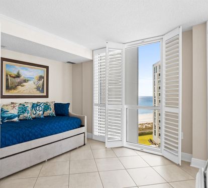Wake up to stunning ocean views from your cozy daybed, where coastal breezes drift through plantation shutters into your serene retreat.