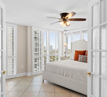Drift off in your sun-soaked sanctuary with stunning city views through plantation shutters and gentle ceiling fan breezes.