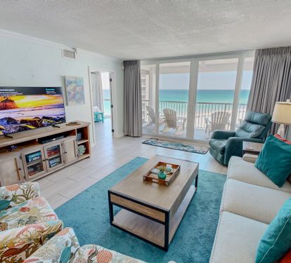 Unwind in your oceanfront living room where turquoise accents mirror the sea views through floor-to-ceiling windows onto your private balcony.