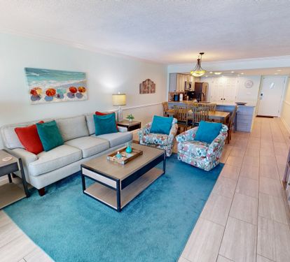 Your bright, coastal-themed living space features a comfortable sectional sofa and vibrant turquoise accents that perfectly complement the ocean artwork above.