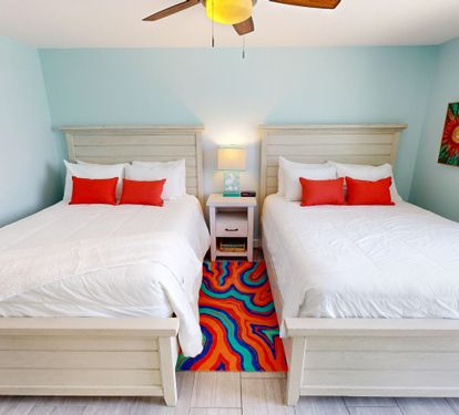 Drift off to sleep in your cheerful twin bedroom, where soft aqua walls and vibrant artwork create a peaceful retreat after your island adventures.