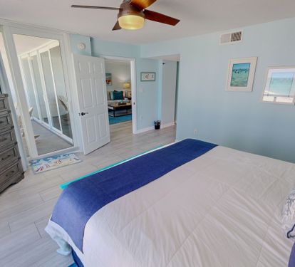 Drift into peaceful sleep in your coastal-themed bedroom, complete with ceiling fan, TV, and serene blue accents that mirror the nearby ocean.
