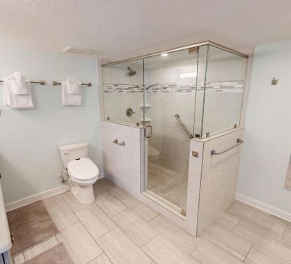 Step into your spacious, accessible bathroom featuring a walk-in shower with grab bars, premium fixtures, and thoughtful design for comfort and safety.