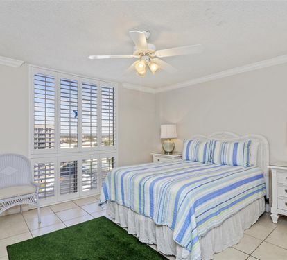 Drift off to sleep in your comfortable bed while the coastal breeze flows through plantation shutters, creating a peaceful beachside retreat.