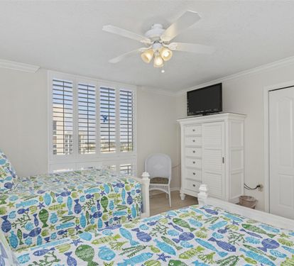 Rest peacefully in your bright bedroom featuring twin beds with cheerful coastal linens and plenty of storage space for your belongings.