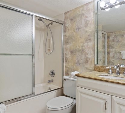 Step into your private bathroom with a spacious glass shower, granite counters, and fluffy towels waiting for your relaxing soak.