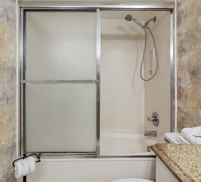 Your elegant bathroom features a spacious tub-shower combo with polished fixtures and fresh towels ready for your relaxing soak.