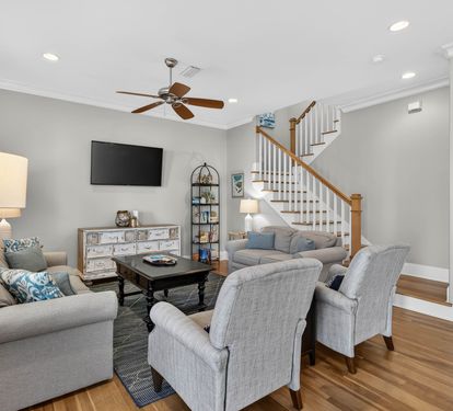 Relax in this bright living space with plush seating, warm wood floors, and coastal-inspired decor that welcomes you home.