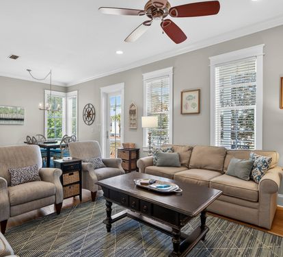 Relax in this beautifully appointed living room with comfortable seating, thoughtful decor, and plenty of natural light streaming through plantation shutters.