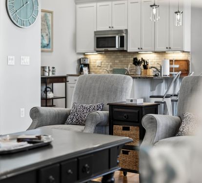 Sink into these plush armchairs and feel instantly at home in your thoughtfully designed open-concept space, where the modern kitchen awaits your culinary adventures.