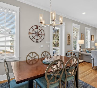 Gather around your elegant dining table where nautical touches and warm lighting create memorable meals together.