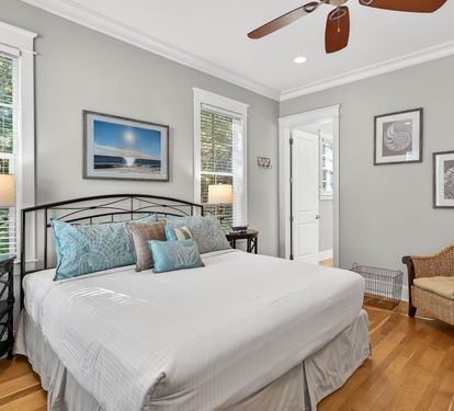 Drift off in this serene bedroom with soft coastal hues, warm hardwood floors, and gentle breezes from your ceiling fan overhead.
