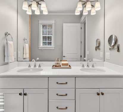 Step into your private spa-like bathroom with dual vanities, elegant lighting, and fresh towels awaiting your arrival.