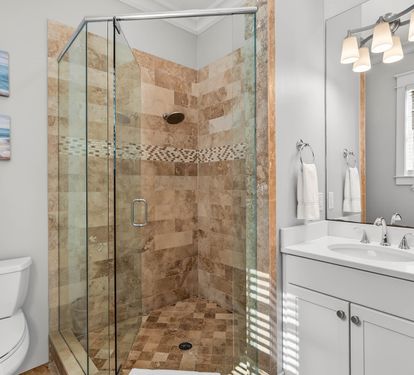 Indulge in your private spa-like bathroom with beautiful stone tile shower, double vanity, and elegant lighting for your morning routine.