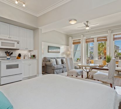 Bright and inviting 30A studio with a full kitchen, plush queen bed, and cozy living space. Floor-to-ceiling windows fill the room with natural light, creating a perfect coastal escape.