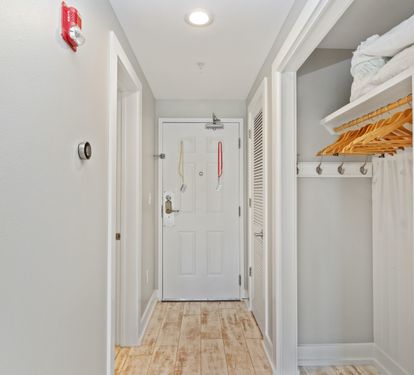 Welcoming entryway with coastal tones, wood-style floors, and a convenient open closet—setting the stage for your relaxing 30A beach stay.