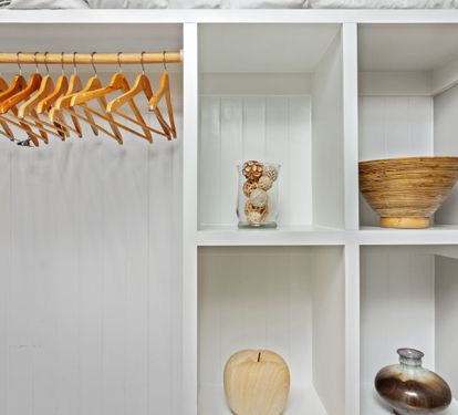 Thoughtfully designed open closet with wooden hangers and decorative shelving—offering both style and storage for your 30A vacation essentials.