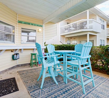 Your charming covered patio features turquoise chairs and table where you can enjoy morning coffee or evening drinks in comfort.