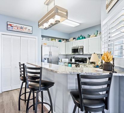 Your fully equipped kitchen awaits with granite countertops and breakfast bar seating for casual coastal dining.