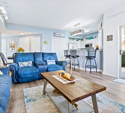 Relax in your bright, open-concept space with plush blue leather seating and modern kitchen access.