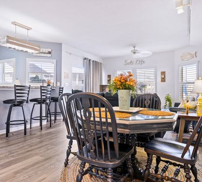 Gather around your elegant dining table for memorable meals, with the open kitchen perfect for cooking together and coastal decor creating a relaxing atmosphere.