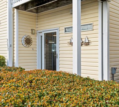 A welcoming entrance with charming nautical touches and seasonal foliage creates your perfect coastal retreat arrival.