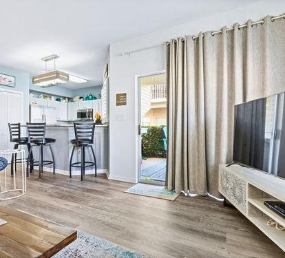 Relax in your bright open-plan living space with modern kitchen, cozy seating, and sliding door access to your private outdoor area.