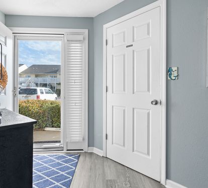 Step into your coastal retreat where soft blue walls welcome you home. The bright entryway flows seamlessly to your outdoor space.