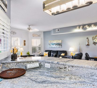 Your open-concept living space features stunning granite countertops perfect for meal prep, while coastal decor creates a relaxing atmosphere.