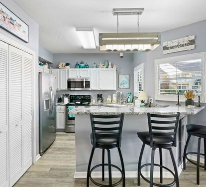 Your fully equipped kitchen features granite countertops and breakfast bar seating, perfect for preparing meals and casual dining together.